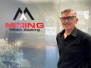 Mike Allen in front of Mining Wear Parts logo