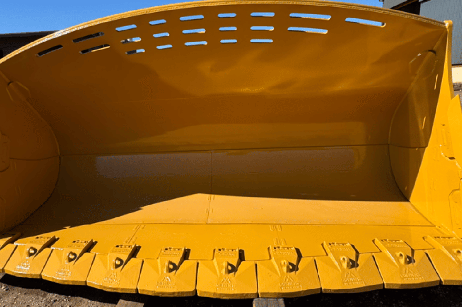 Installed loader bucket GET showing cutting edges and wear parts in operation